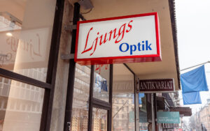 Ljungs Optik butiksfasad på Norrtullsgatan i Stockholm, med belyst skylt i rött och vitt